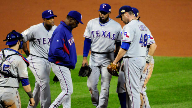 Oct 27, 2011; St. Louis, MO, USA; Texas Rangers manager Ron Washington (in blue) comes out to relieve starting pitcher Colby Lewis (48) in the sixth inning in game six of the 2011 World Series against the St. Louis Cardinals at Busch Stadium. Mandatory Credit: Jeff Curry-USA TODAY Sports