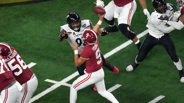 Cincinnati Bearcats defensive lineman Curtis Brooks (92) pressured Alabama Crimson Tide quarterback Bryce Young (9) as he throws in the third quarter during the College Football Playoff semifinal game at the 86th Cotton Bowl Classic, Friday, Dec. 31, 2021, at AT&T Stadium in Arlington, Texas. The Alabama Crimson Tide defeated the Cincinnati Bearcats, 27-6.