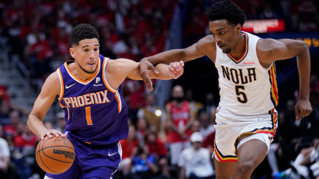 Phoenix Suns guard Devin Booker (1) drives to the basket against New Orleans Pelicans forward Herbert Jones (5) in the second half of Game 6 of an NBA basketball first-round playoff series, Thursday, April 28, 2022 in New Orleans. The Suns won 115-109, to win the series 4-2 and advance to the second-round.