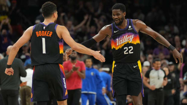 May 2, 2022; Phoenix, Arizona, USA; Phoenix Suns guard Devin Booker (1) and Phoenix Suns center Deandre Ayton (22) slap hands against the Dallas Mavericks during the first half of game one of the second round for the 2022 NBA playoffs at Footprint Center. Mandatory Credit: Joe Camporeale-USA TODAY Sports