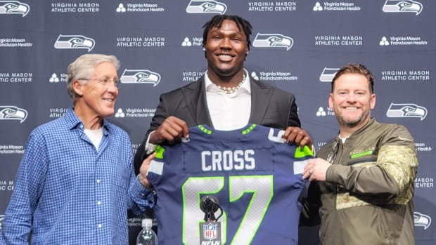 Seahawks first-round pick Charles Cross holds his new jersey alongside coach Pete Carroll and general manager John Schneider.