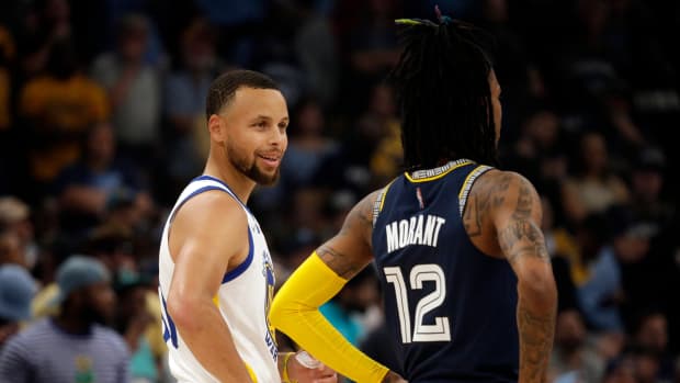 Warriors guard Stephen Curry (left) talks with Grizzlies guard Ja Morant (12) during a timeout in Game 2.