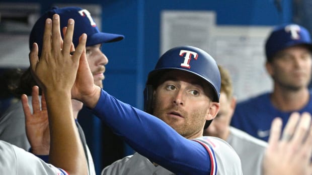 Apr 9, 2022; Toronto, Ontario, CAN; Texas Rangers left fielder Brad Miller (13) is greeted in the dugout by team mates after scoring against the Toronto Blue Jays in the third inning at Rogers Centre. Mandatory Credit: Dan Hamilton-USA TODAY Sports