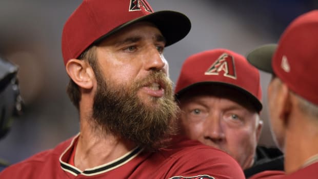 Arizona Diamondbacks’ pitcher Madison Bumgarner is restrained by bench coach Jeff Banister, rear, while arguing with umpires after the first inning of a baseball game against the against the Miami Marlins, Wednesday, May 4, 2022, in Miami.