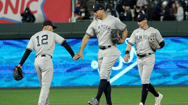 New York Yankees’ Isiah Kiner-Falefa (12), Giancarlo Stanton, center, and Tim Locastro celebrate after their baseball game against the Kansas City Royals Saturday, April 30, 2022, in Kansas City, Mo. The Yankees won 3-0.