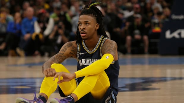 Grizzlies guard Ja Morant sits on the ground during a game.