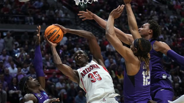 Mar 20, 2022; San Diego, CA, USA; Arizona Wildcats center Christian Koloko (35) shoots against TCU Horned Frogs forward Emanuel Miller (2) and forward Xavier Cork (12) and forward Chuck O'Bannon Jr. (5) in the first half during the second round of the 2022 NCAA Tournament at Viejas Arena. Mandatory Credit: Kirby Lee-USA TODAY Sports