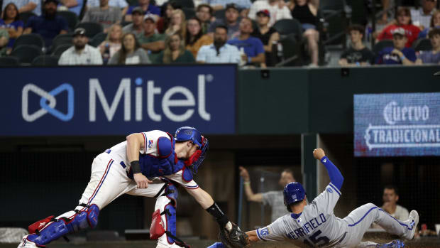 May 11, 2022; Arlington, Texas, USA; Kansas City Royals second baseman Whit Merrifield (15) scores ahead of the tag of Texas Rangers catcher Sam Huff (55) during the ninth inning at Globe Life Field.