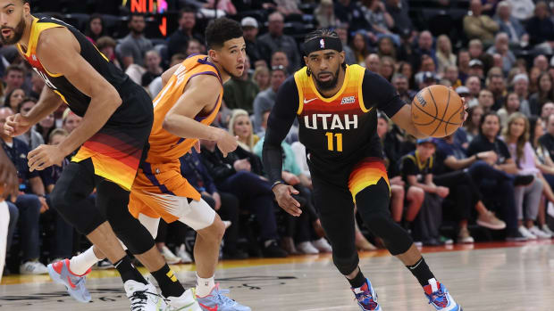 Utah Jazz guard Mike Conley (11) uses a screen set by center Rudy Gobert (27) against Phoenix Suns guard Devin Booker (1) in the first quarter at Vivint Arena.