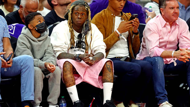 Lil Wayne sitting in the front row of a Suns game.