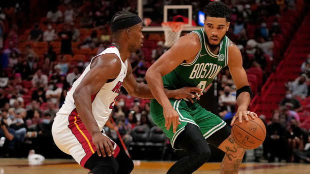 Boston Celtics forward Jayson Tatum (0) dribbles the ball around Miami Heat forward Jimmy Butler.