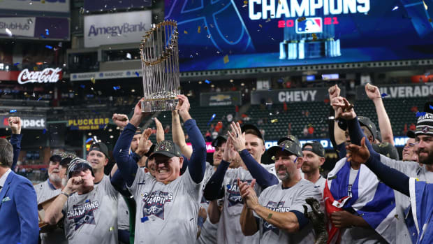 Atlanta Braves manager Brian Snitker hoists the Commissioner's Trophy after defeating the Houston Astros in game six of the 2021 World Series at Minute Maid Park.
