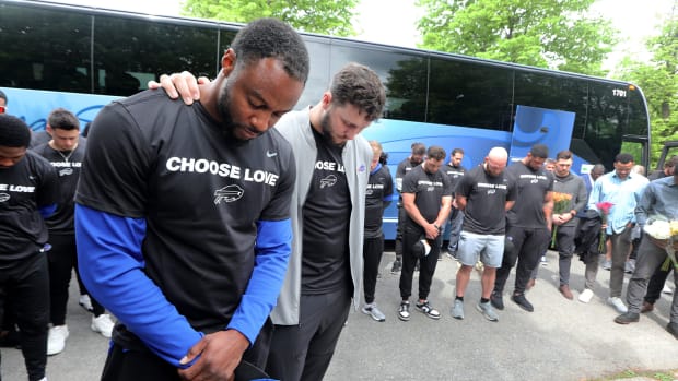 Buffalo Bills running back Taiwan Jones and Quarterback Josh Allen pray with their teammates near the site of the last Saturday’s mass shooting at the Tops supermarket in Buffalo, N.Y. May 18, 2022. Members or the team visited the site and then helped distribute food to members of the community.