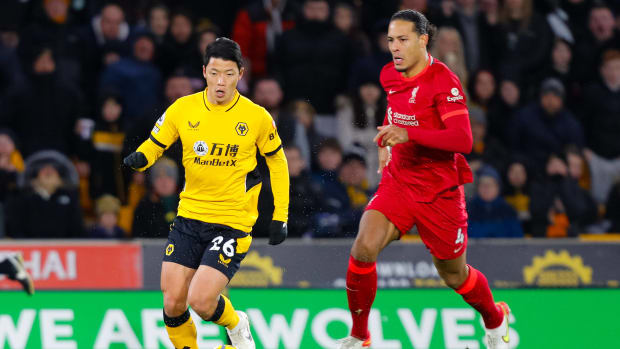 Liverpool defender Virgil van Dijk (right) pictured in pursuit of Wolves forward Hwang Hee-chan during a Premier League game at Molineux in December 2021