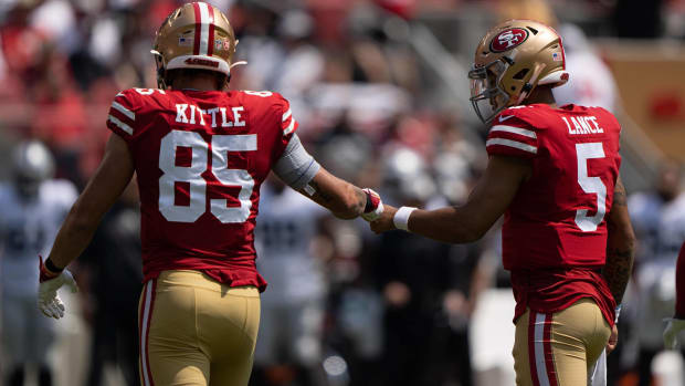 George Kittle and Trey Lance bump fists.