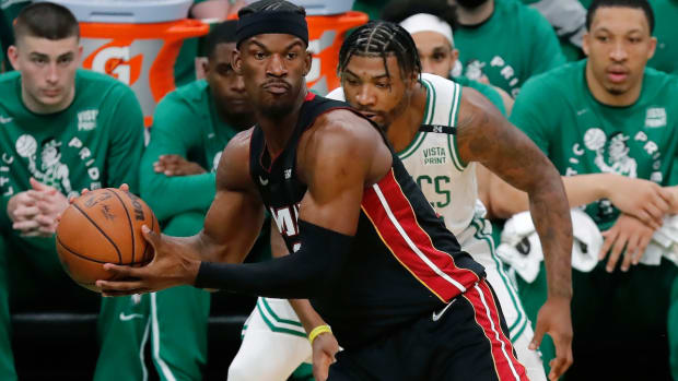 Miami Heat’s Jimmy Butler (22) intercepts a pass intended for Boston Celtics’ Marcus Smart, behind, during the first half of Game 3 of the NBA basketball playoffs Eastern Conference finals Saturday, May 21, 2022, in Boston. (AP Photo/Michael Dwyer)