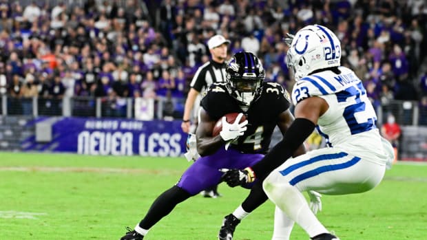 Oct 11, 2021; Baltimore, Maryland, USA; Baltimore Ravens running back Ty'Son Williams (34) rushes by Indianapolis Colts cornerback Kenny Moore II (23) during the second half at M&T Bank Stadium. Mandatory Credit: Tommy Gilligan-USA TODAY Sports