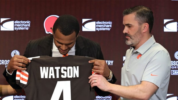 Cleveland Browns quarterback Deshaun Watson, left, admires the nameplate on his new jersey as head coach Kevin Stefanski looks on during Watson’s introductory press conference at the Cleveland Browns Training Facility