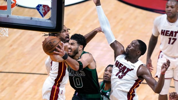 Boston Celtics forward Jayson Tatum (0) drives to the basket as Miami Heat center Bam Adebayo (13) and guard Gabe Vincent (2) defend during the second half of Game 5 of the NBA basketball Eastern Conference finals playoff series, Wednesday, May 25, 2022, in Miami.