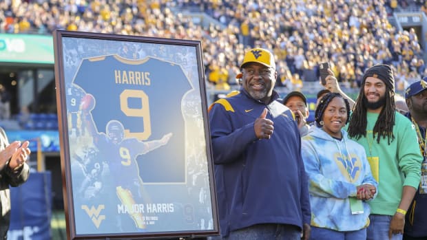 Nov 6, 2021; Morgantown, West Virginia, USA; Former West Virginia Mountaineers player Major Harris waves to the crowd during a ceremony to retire his No. 9 after the first quarter against the Oklahoma State Cowboys at Mountaineer Field at Milan Puskar Stadium.