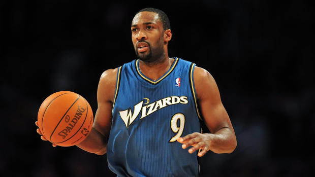 Gilbert Arenas holding a basketball in a Wizards uniform