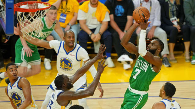Cetlics’ Jaylen Brown shoots over Warriors’ Draymond Green in the NBA Finals.