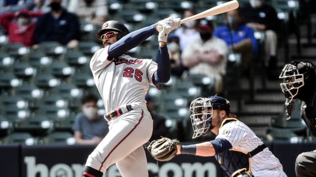 Apr 4, 2021; Milwaukee, Wisconsin, USA;  Minnesota Twins center fielder Byron Buxton (25) hits a double in the first inning as Milwaukee Brewers catcher Manny Pina (9) watches at American Family Field.