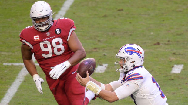 Buffalo Bills quarterback Josh Allen (17) catches a pass in front of Arizona Cardinals defensive tackle Corey Peters (98) and scores a touchdown against the Arizona Cardinals during the first half at State Farm Stadium.