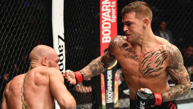 Dustin Poirier punches Conor McGregor of Ireland in a lightweight fight during the UFC 257 event inside Etihad Arena on UFC Fight Island.