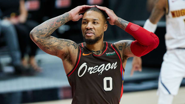 Portland Trail Blazers guard Damian Lillard (0) reacts after being called for a foul against the Denver Nuggets during the third quarter at the Moda Center.