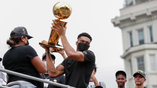 Bucks' Giannis Antetokounmpo hoisting the Larry O'Brien trophy during the championship parade in Milwaukee