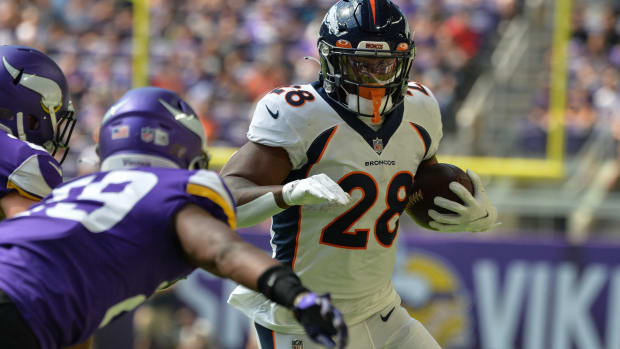 Denver Broncos running back Royce Freeman (28) runs the ball as Minnesota Vikings defensive back Kris Boyd (29) moves in for the tackle during the first quarter at U.S. Bank Stadium.