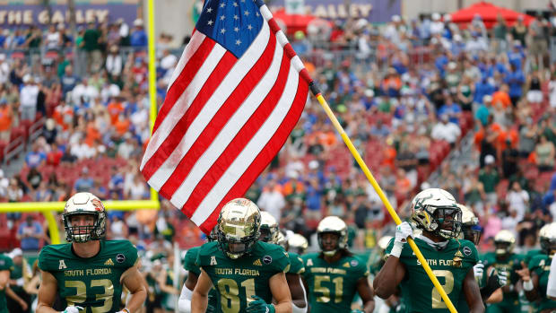 Sep 11, 2021; Tampa, Florida, USA; South Florida Bulls defensive back TJ Robinson (2) carries an American flag in remembrance of 9/11 during the first half against the Florida Gators at Raymond James Stadium.