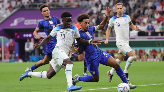 Tyler Adams tackles Bukayo Saka in the USA’s match vs. England at the World Cup