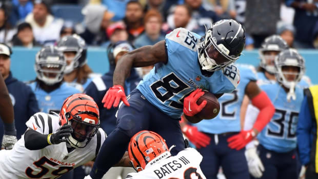 Tennessee Titans tight end Chigoziem Okonkwo (85) is stopped by Cincinnati Bengals linebacker Akeem Davis-Gaither (59) and safety Jessie Bates III (30) after a catch during the second half at Nissan Stadium.