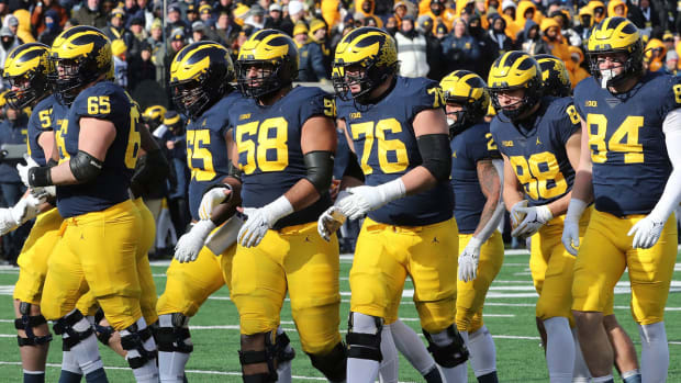 The Michigan offensive line breaks the huddle and moves to the line of scrimmage.