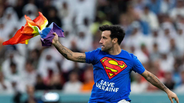 A pitch invader pictured holding a rainbow flag during the World Cup game between Portugal and Uruguay in Qatar