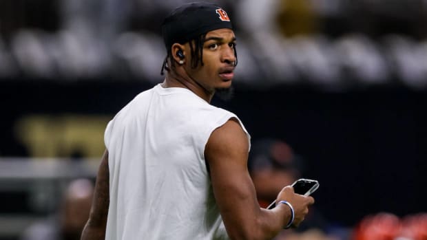 Bengals wide receiver Ja'Marr Chase looks at his phone while warming up before a game vs. the Saints.