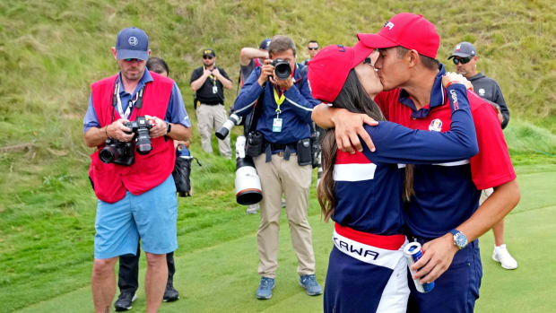 Collin Morikawa and Katherine Zhu kiss after the 2021 Ryder Cup.