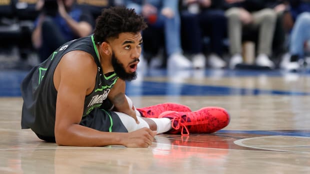 Timberwolves center Karl-Anthony Towns (32) holds his leg after being injured against the Wizards in the third quarter at Capital One Arena.