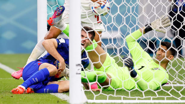United States of America forward Christian Pulisic (10) reacts after colliding with Iran goalkeeper Alireza Beiranvand (1) after scoring a goal during the first half of a group stage during the 2022 World Cup at Al Thumama Stadium.