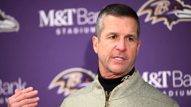 Ravens coach John Harbaugh talks with reporters.