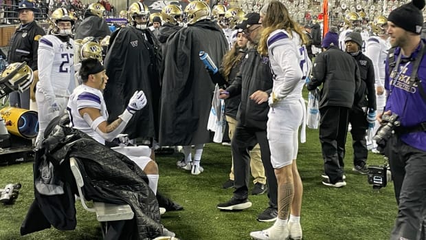 Chuck Morrell talks with UW defensive backs Kam Fabiculanan, seated, and Asa Turner (20) near the end of the Apple Cup.