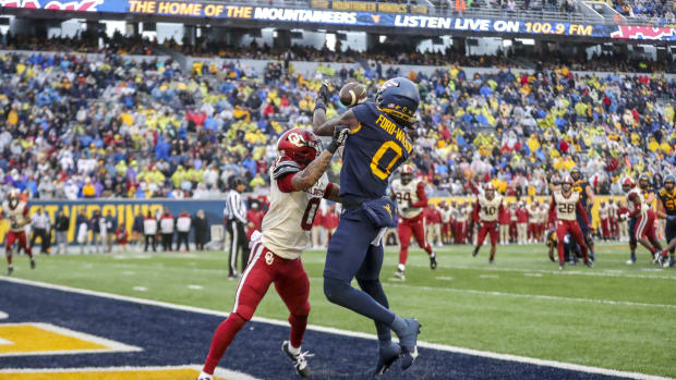 Nov 12, 2022; Morgantown, West Virginia, USA; West Virginia Mountaineers wide receiver Bryce Ford-Wheaton (0) catches a pass for a touchdown over Oklahoma Sooners defensive back Woodi Washington (0) during the third quarter at Mountaineer Field at Milan Puskar Stadium. Mandatory Credit: Ben Queen-USA TODAY Sports