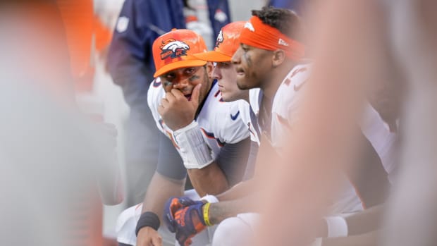 Denver Broncos quarterback Russell Wilson (3) talks with teammates near the end of the second half against the Carolina Panthers at Bank of America Stadium.