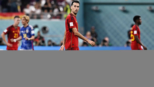 Sergio Busquets and Spain walk off the pitch after losing to Japan.