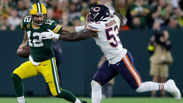 Packers quarterback Aaron Rodgers stiff-arms Bears linebacker Nicholas Morrow.