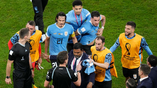 Uruguay players argue with the German referee Daniel Siebert at the end of the World Cup group H soccer match against Ghana.