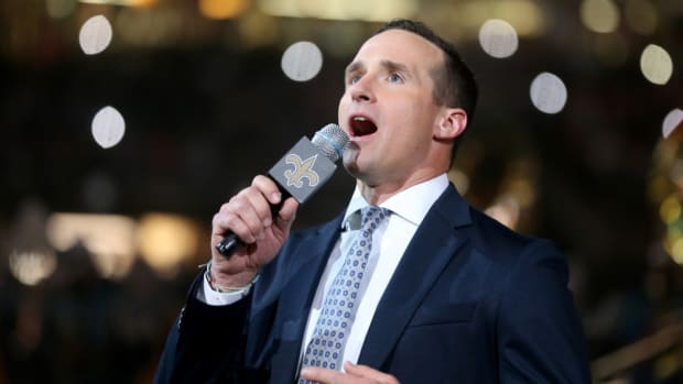 Drew Brees speaks into a microphone during a Saints game.