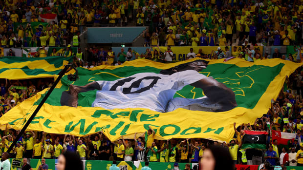 Brazilian fans hold a flag honoring Pelé as the legend undergoes treatment for colon cancer.